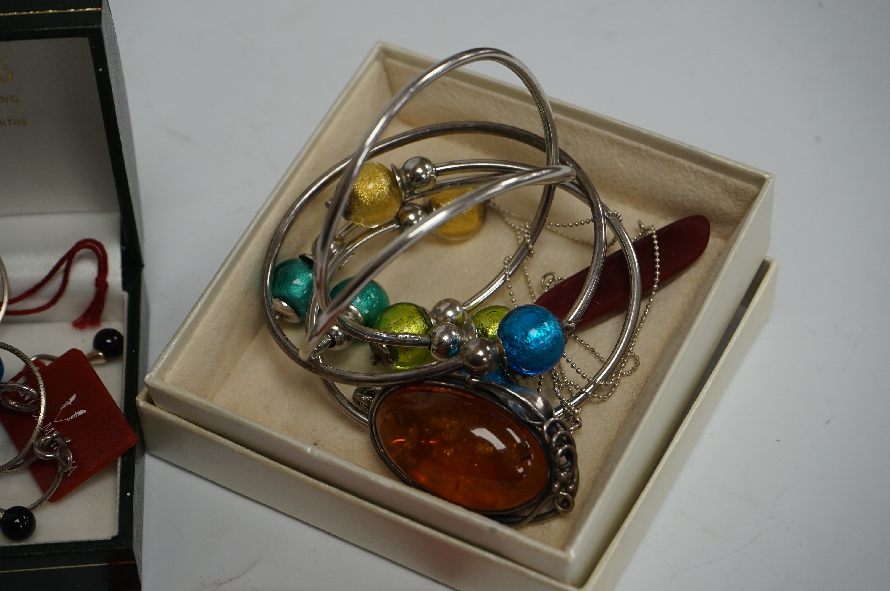 Four assorted modern 800 standard white metal and glass bangles and other white metal jewellery including a silver mounted amber pendant. Condition - fair to good